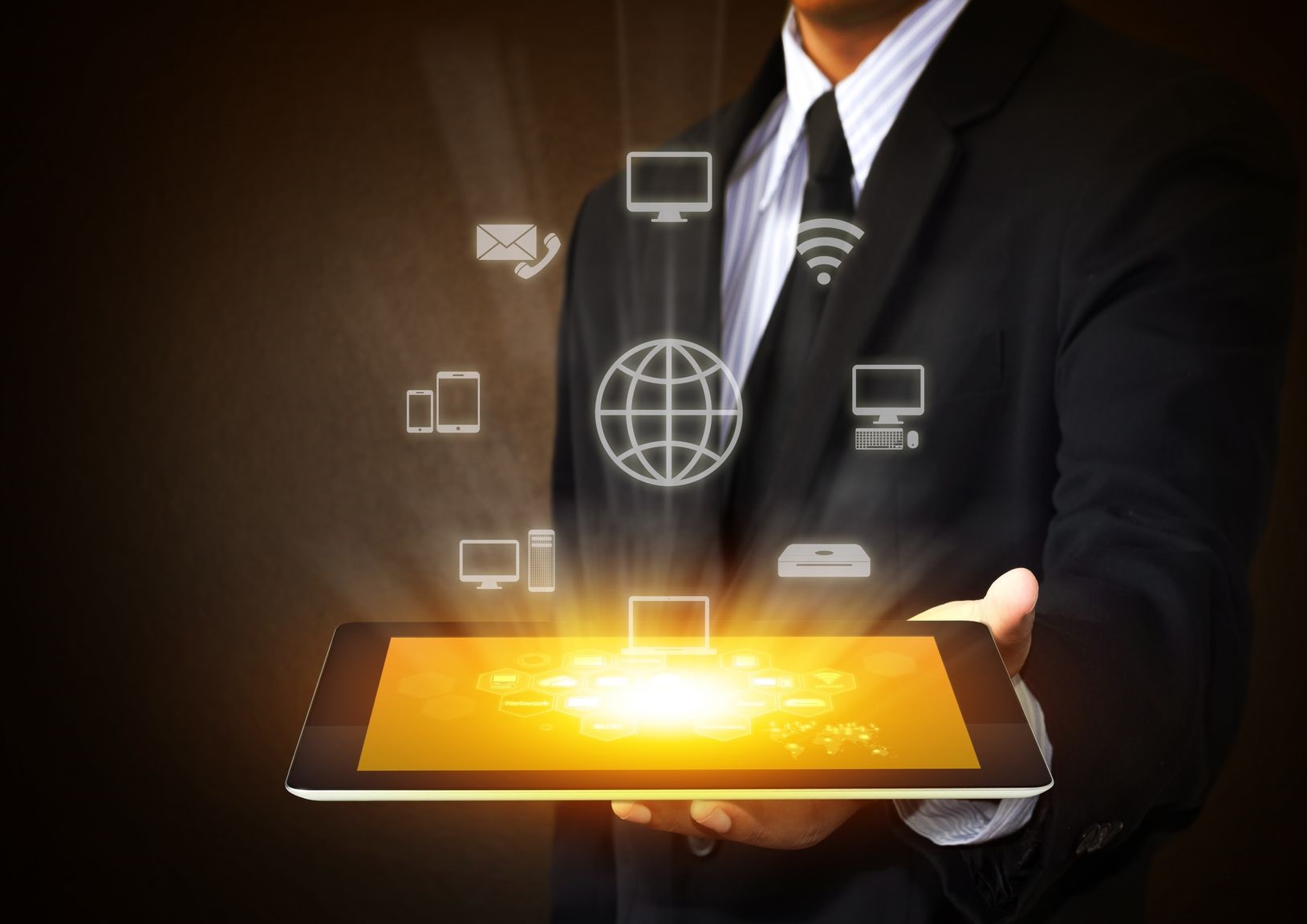 Ein Mann im Anzug hält ein Tablet mit leuchtenden digitalen Symbolen für Vernetzung.